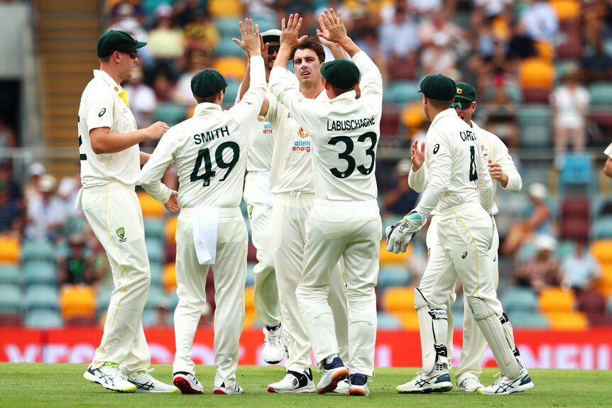 Australian teammates congratulate Pat Cummins on taking the wicket of England batter ROry Burns during the Ashes.