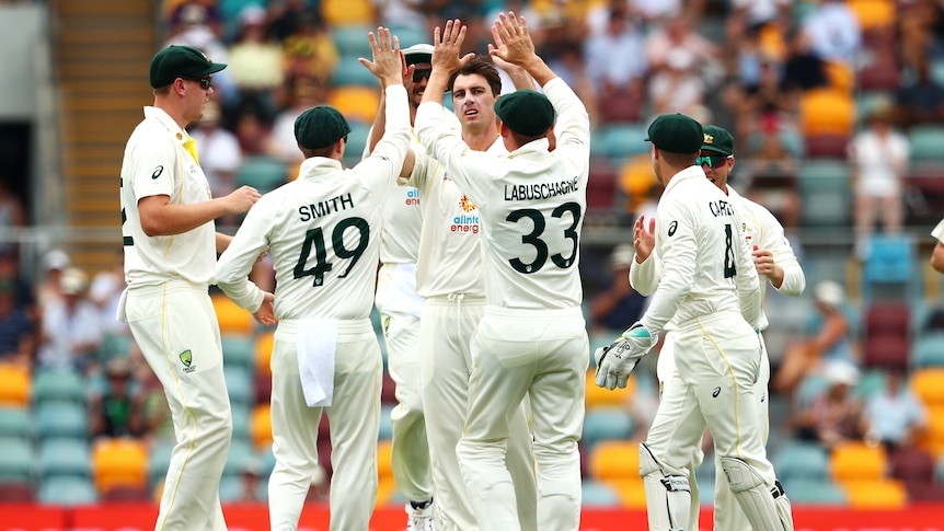 Australian teammates congratulate Pat Cummins on taking the wicket of England batter ROry Burns during the Ashes.