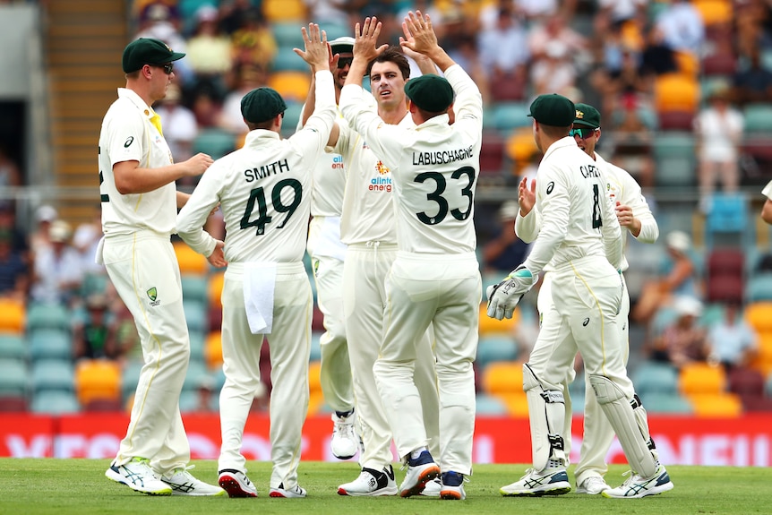 Australian teammates congratulate Pat Cummins on taking the wicket of England batter ROry Burns during the Ashes.