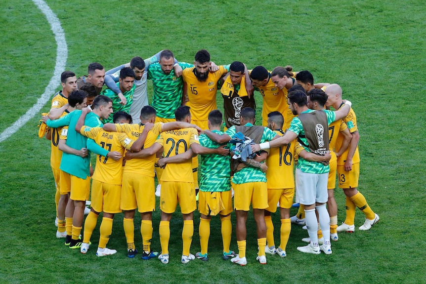Socceroos players form huddle in the middle of the pitch