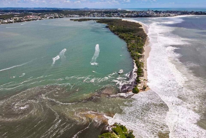 An aerial view of an island being divided in two by the ocean.