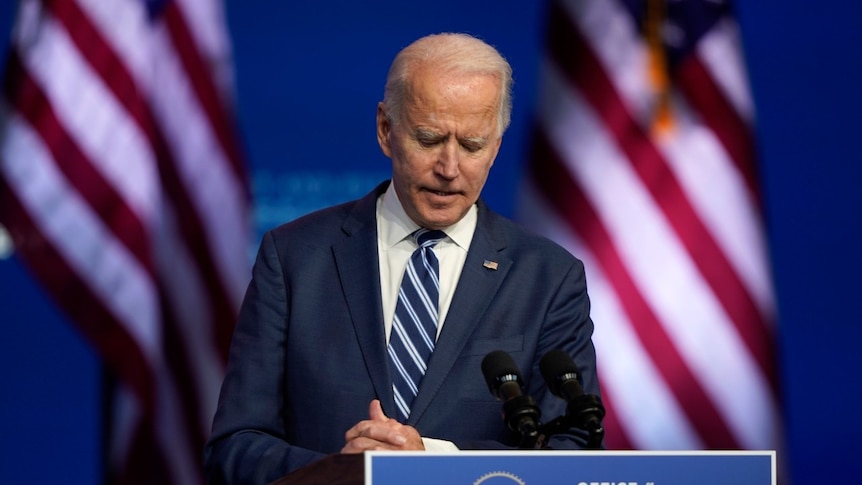 President-elect Joe Biden listens to a question from a reporter