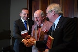 Former prime minister Tony Abbott (left) shakes hands with Dr Kevin Donnelly (right) as broadcaster Alan Jones looks on.