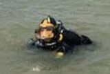 The head of a police diver is seen in a river.