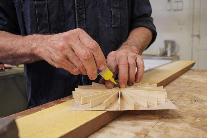 Close-up shot of Mr Morgan gluing the radiant soundboard together.