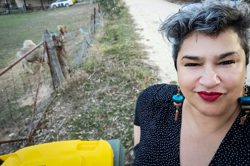 Maria glammed up in make-up for bin night with a dirt road behind her.