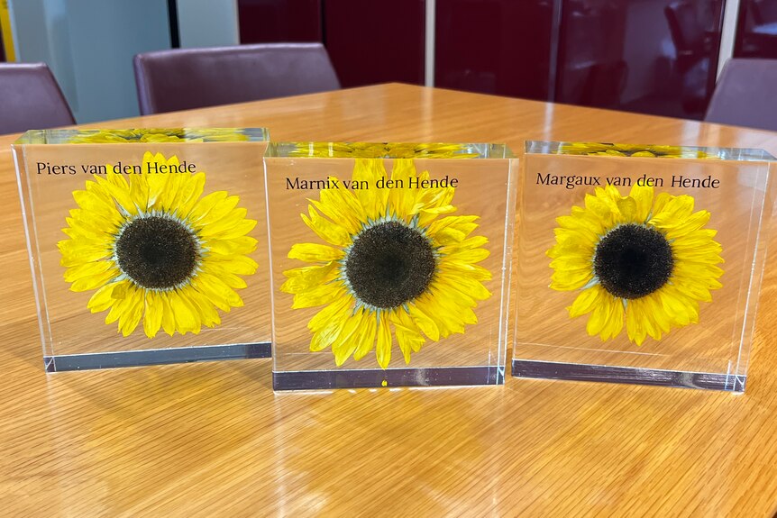 Three sunflower perspex plaques contain the names of Piers, Marnix and Margaux.
