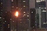 Orange flames spread up a multi-storey apartment complex.