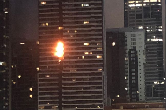 Orange flames spread up a multi-storey apartment complex.