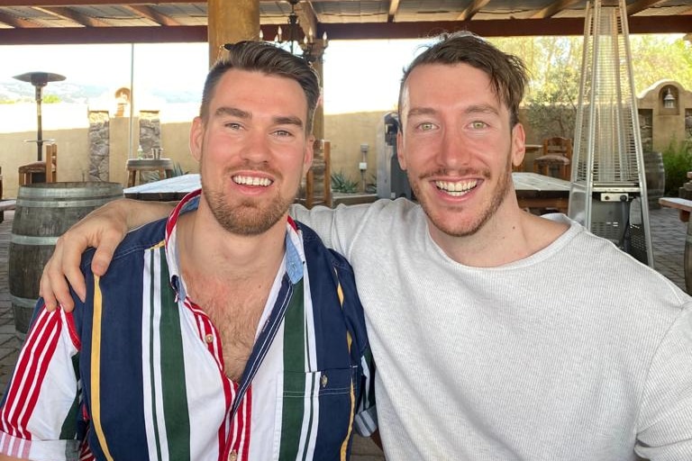 two young men smiling in a restaurant 