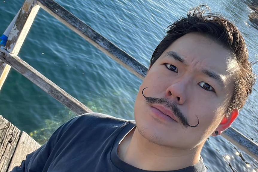 A man with a handlebar moustache on a jetty