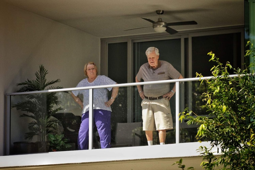 Elderly couple exercise with squats on their balcony at Yeronga Retirement Village and Regis Aged Care in Brisbane.