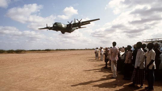 Local Kenyan workers watch a C-130 Hercules (Getty Images: USAF)