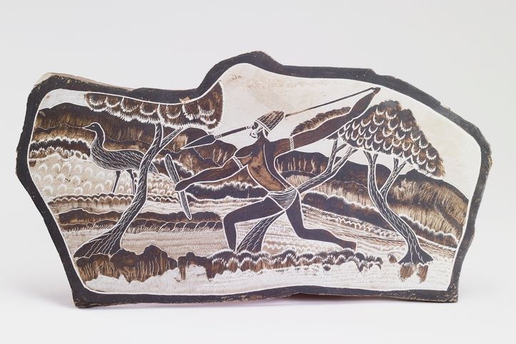 A slate plaque painted with an Aboriginal hunting scene