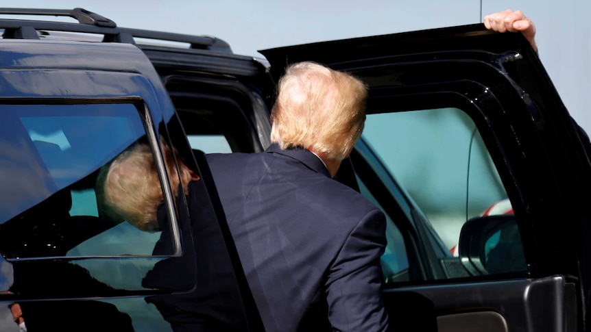 Donald Trump gets into a black car
