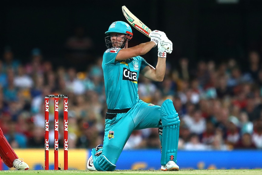Cricketer Chris Lynn gets down on one knee and watches the ball fly over the rope after hitting a cut shot for six. 