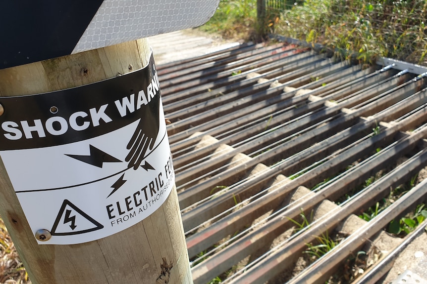 Electric fencing sign says 'shock warning'.