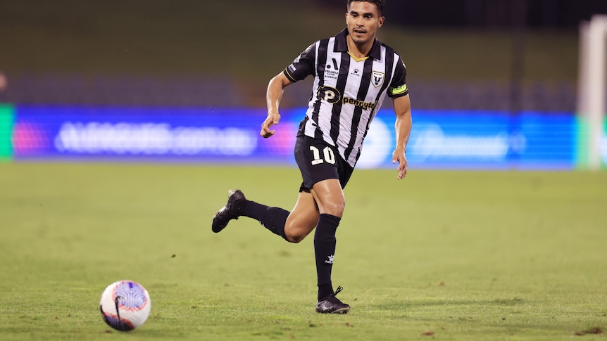 Ulises Davila wearing black and white kit of the Bulls passes the ball during the A-League Men Round 19 match