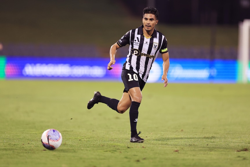 Ulises Davila wearing black and white kit of the Bulls passes the ball during the A-League Men Round 19 match