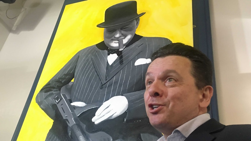 Nick Xenonophon points to a portrait of former British PM Winston Churchill.