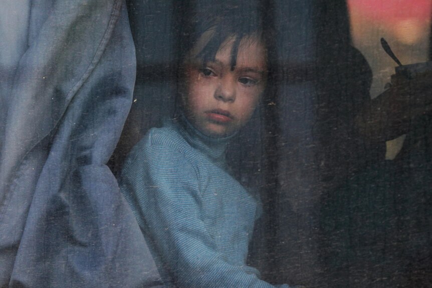 A child looks out of a bus window as civilians evacuated from the Russian-controlled Kherson region of Ukraine