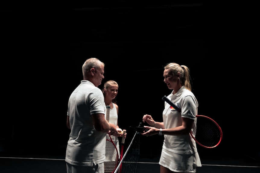 Three tennis players standing together in a black background