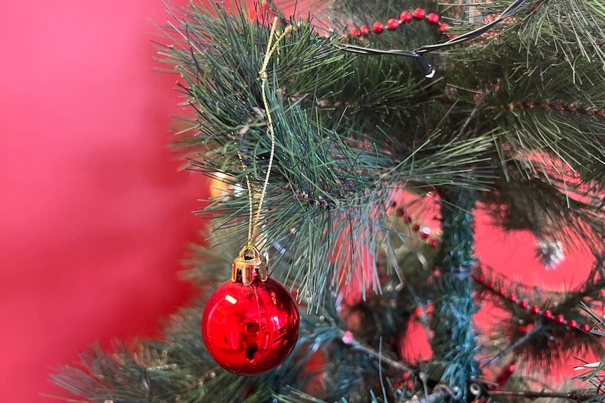 a plastic tree with red baubles