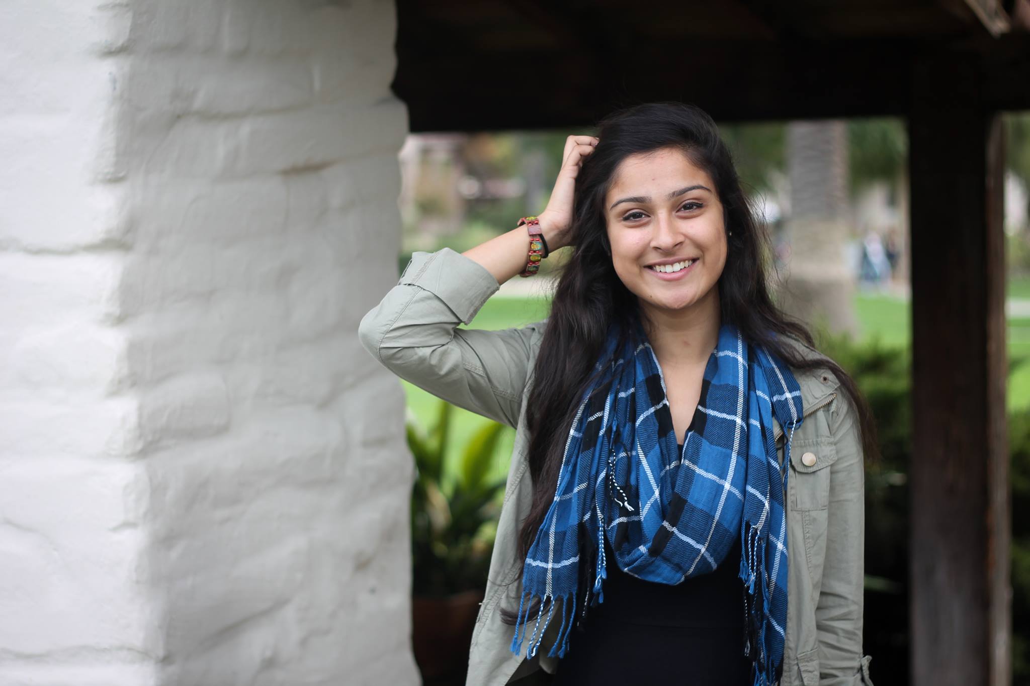 A woman with long, dark hair smiles at the camera