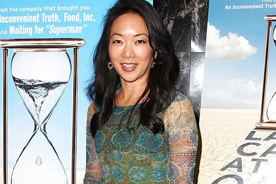 Director Jessica Yu stands on the red carpet at an event in front of a poster for a movie.