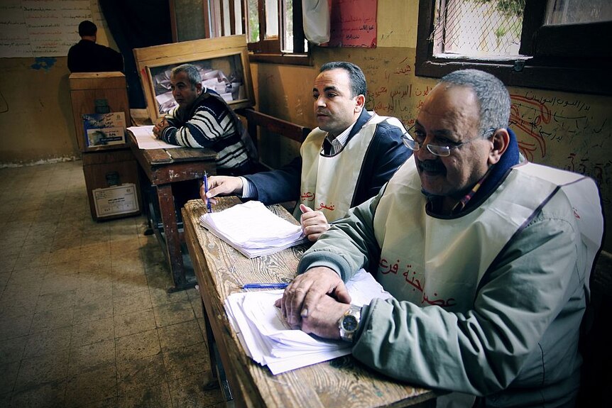 Electoral officials sit at a desk in a polling booth in Ain el-Sira, Cairo.
