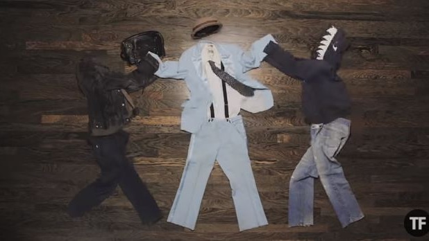 Clothes laid out on the floor to create a character in a blue suit being mugged by two others.