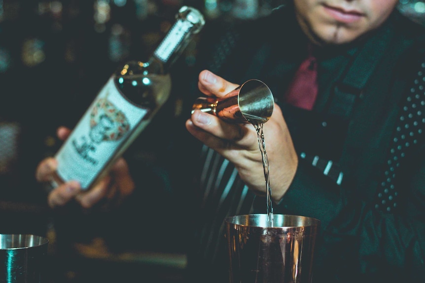 Bartender mixing tequila on table.