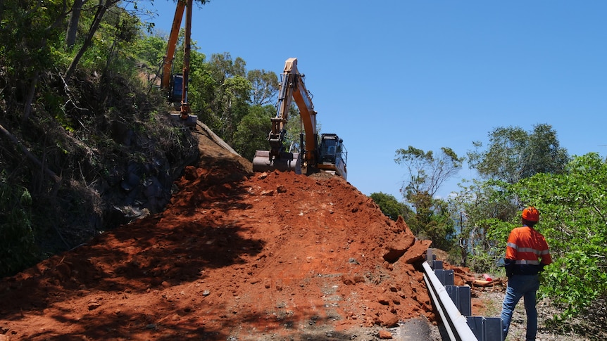 An excavator works to repair a damaged road