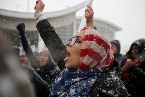 A woman wearing an American flag protests in Detroit