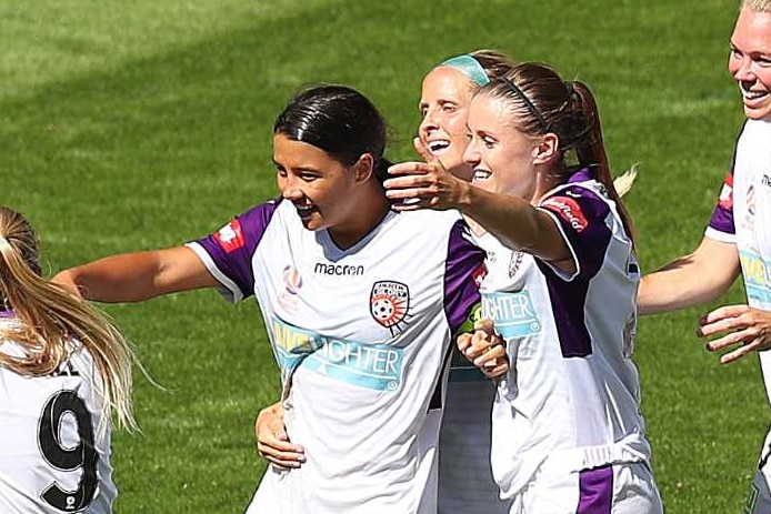 Two Perth Glory soccer players embrace in celebration.