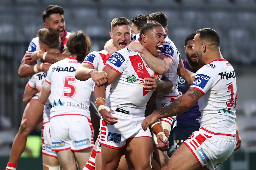 A group of St George Illawarra NRL players embrace as they celebrate a try against Melbourne Storm.