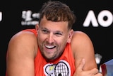 An Australian male tennis player smiles as he speaks to the media at Melbourne Park.