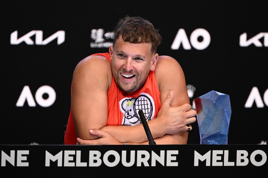 An Australian male tennis player smiles as he speaks to the media at Melbourne Park.