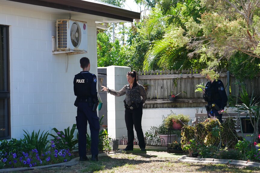 A uniformed police officer faces a female detective searching for evidence at a  Hermit Park address.