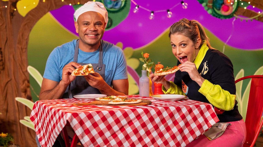 Luke and Rachael eating pizza on the Play School set