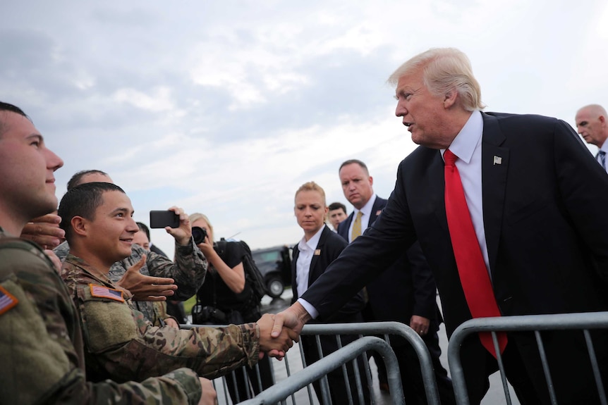 Donald Trump shakes hands with members of the military as he arrives at Raleigh County Memorial Airport in Beaver, West Virginia