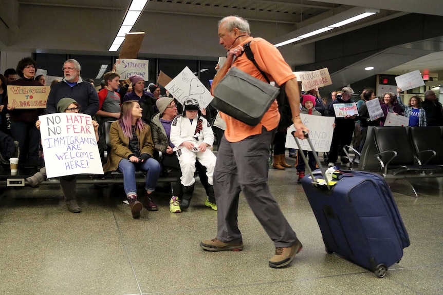 Passengers are greeted by protesters at the gate