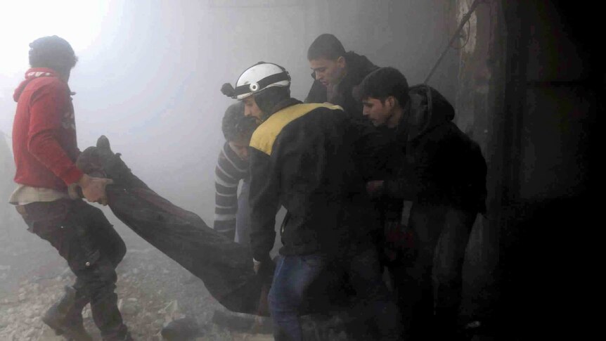 Members of the Syrian Civil Defence group carry a man who was wounded during airstrikes