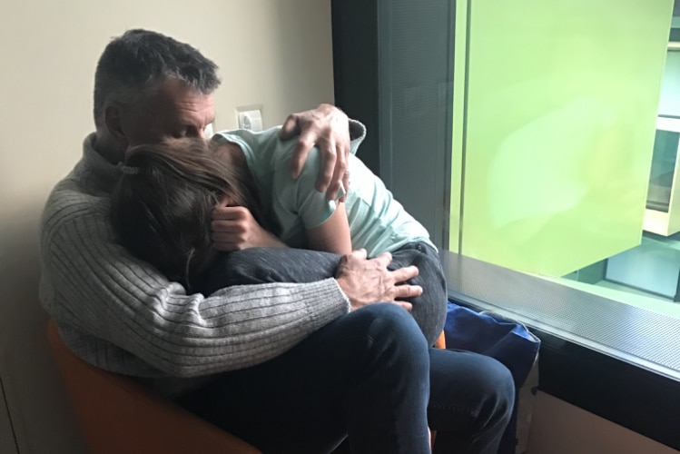 Rod Williams comforts his daughter Charli during a stint of inpatient care 