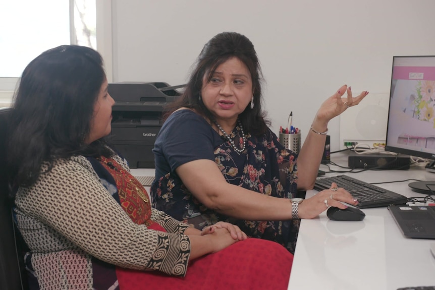 Preeti and Heena sit in front a computer