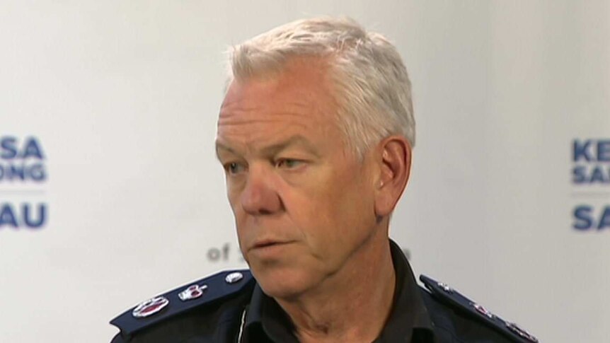 A man with white hair wearing a police officer's uniform