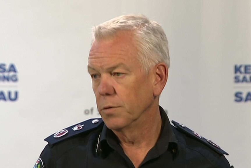 A man with white hair wearing a police officer's uniform