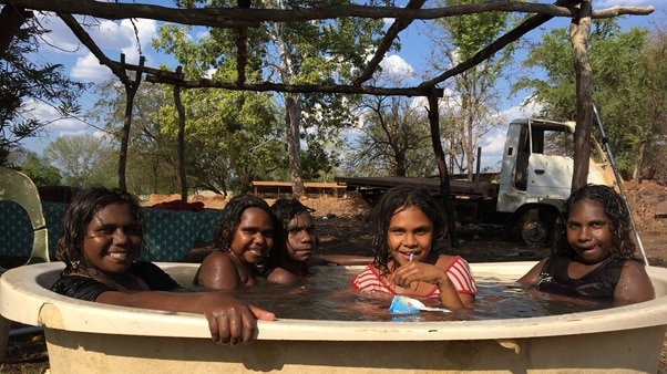 Children sit in an outdoor bath