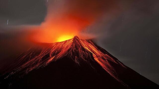 Lava spews from volcano at night