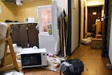 Furniture and electrical appliance are scattered at an apartment.